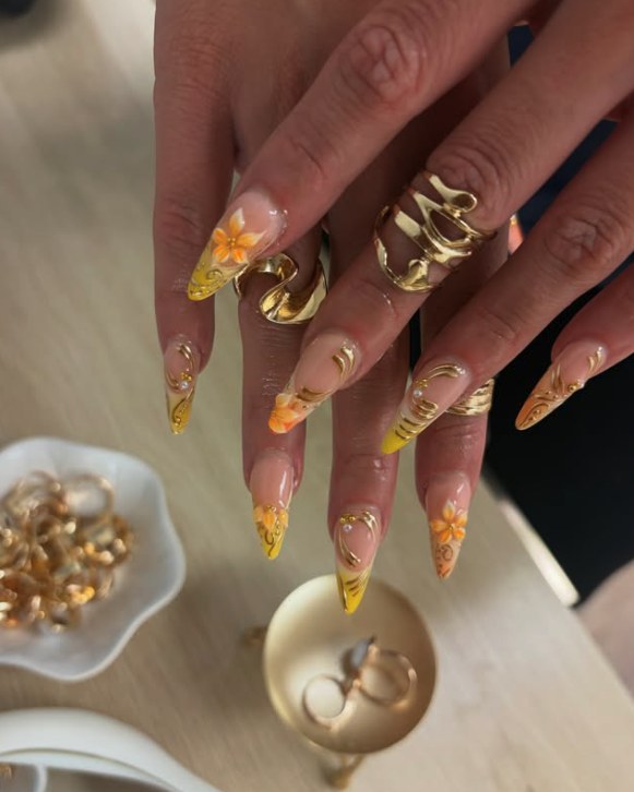 Stiletto nails with gold chrome swirls and orange flowers